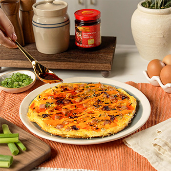 A crispy rice omelette recipe topped with furikake, spam, and chili crisp oil.