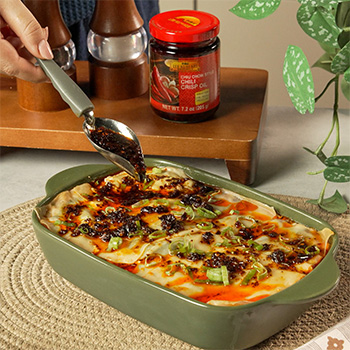 A dumpling lasagna recipe with a mapo tofu inspired filling, topped with chili crisp oil.