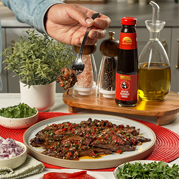 A grilled steak recipe, marinated with oyster sauce and dressed with chimichurri rojo sauce.