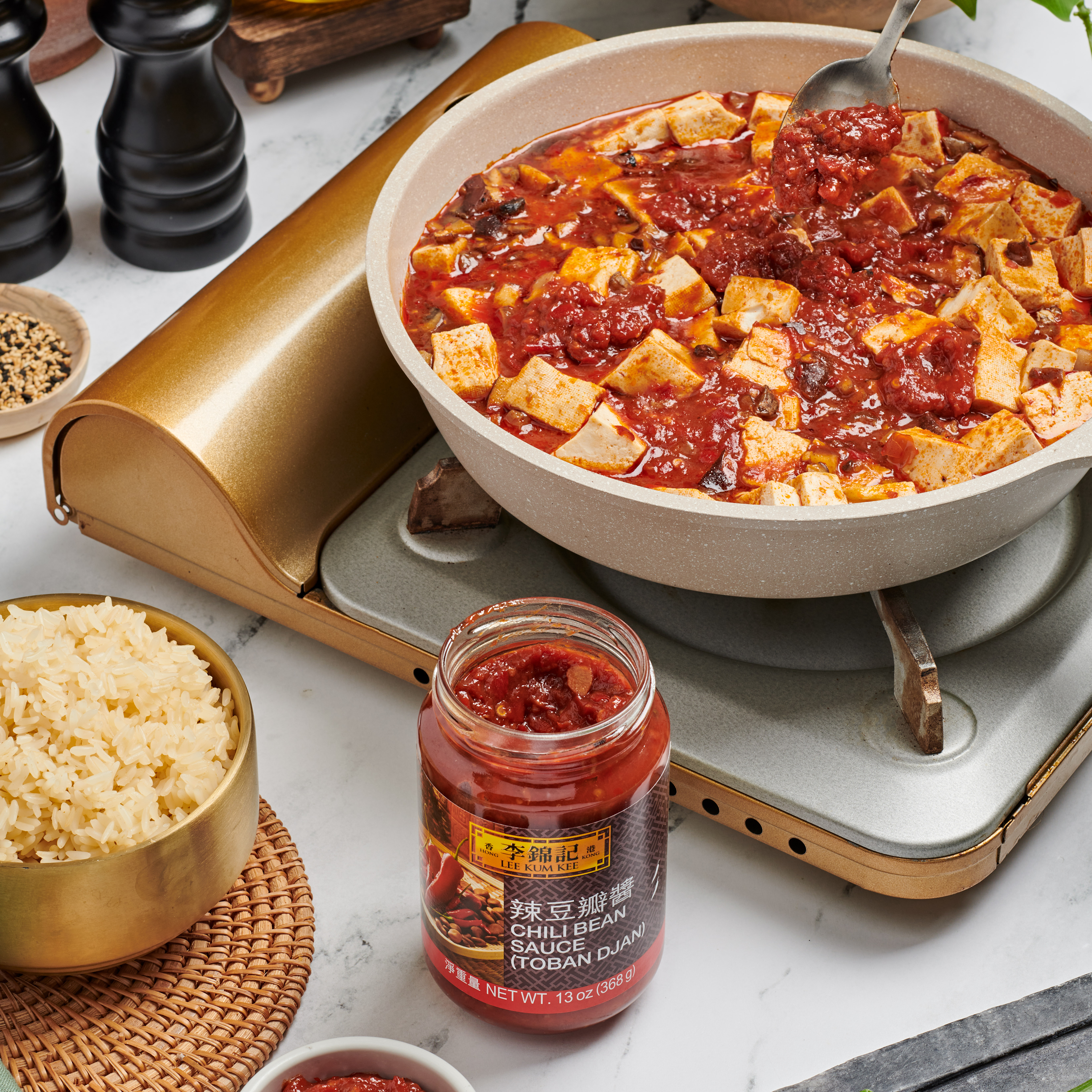 A completed ma po tofu recipe in a bowl alongside rice and Lee Kum Kee Chili Bean Sauce