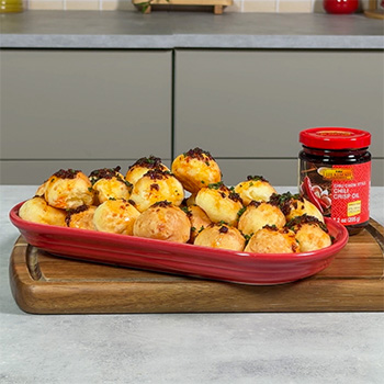 A pao de queijo recipe for Brazilian cheese bread topped with chili crisp oil.