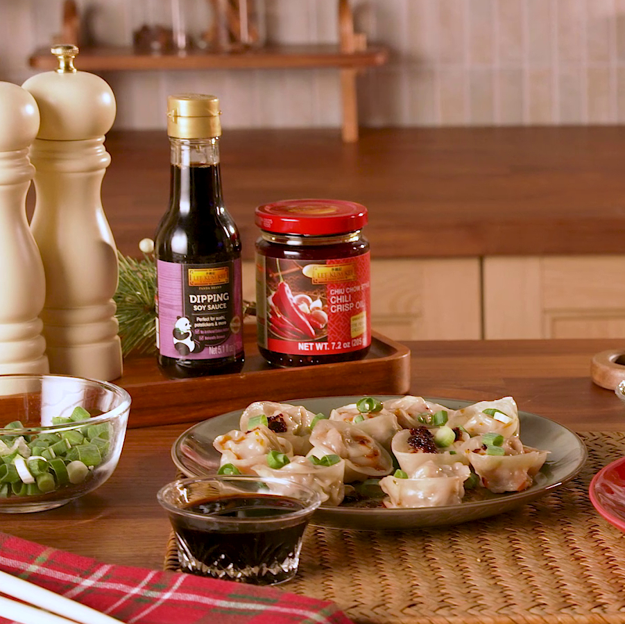 A Pork and Cabbage Dumplings recipe batch for a crowd, served with Lee Kum Kee Chiu Chow Style Chili Crisp Oil for dipping.