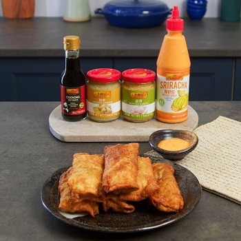 A plate of chicken avocado egg rolls alongside Lee Kum Kee condiments
