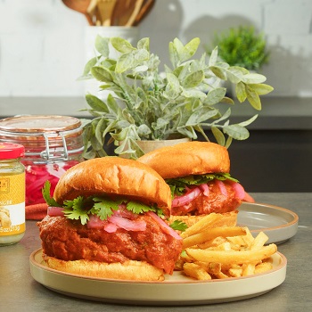 Two chicken tikka masala sandwiches plated with fries alongside Lee Kum Kee ingredients