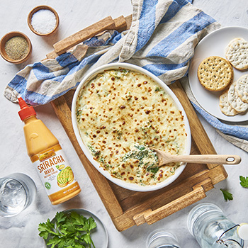 Casserole dish with prepared spinach and artichoke dip from Lee Kum Kee’s easy spinach and artichoke dip recipe.