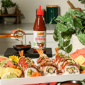 A surf and turf sushi roll platter topped with various flavors of sriracha sauce.